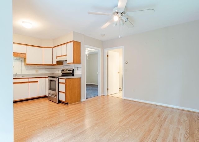 919 College St, Lewiston, ME 04240 - kitchen with stainless steel electric range oven, under cabinet range hood, light wood-type flooring, a ceiling fan, and light countertops