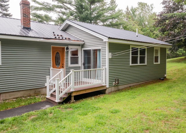 919 College St, Lewiston, ME 04240 - view of front of home featuring a front lawn, a metal roof, and a chimney