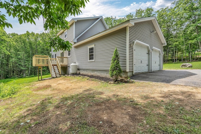 31 Pond Ridge Dr, Lewiston, ME 04240 - view of side of home with asphalt driveway, a garage, a deck, stairway, and a lawn