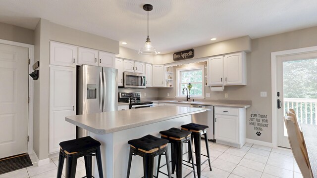 31 Pond Ridge Dr, Lewiston, ME 04240 - kitchen featuring appliances with stainless steel finishes, light tile patterned floors, white cabinets, a breakfast bar area, and recessed lighting