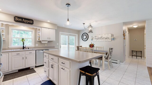 31 Pond Ridge Dr, Lewiston, ME 04240 - kitchen featuring stainless steel dishwasher, light tile patterned floors, a kitchen island, light countertops, and white cabinets