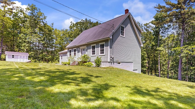 31 Pond Ridge Dr, Lewiston, ME 04240 - view of front of house with a chimney, a front yard, a storage shed, and entry steps