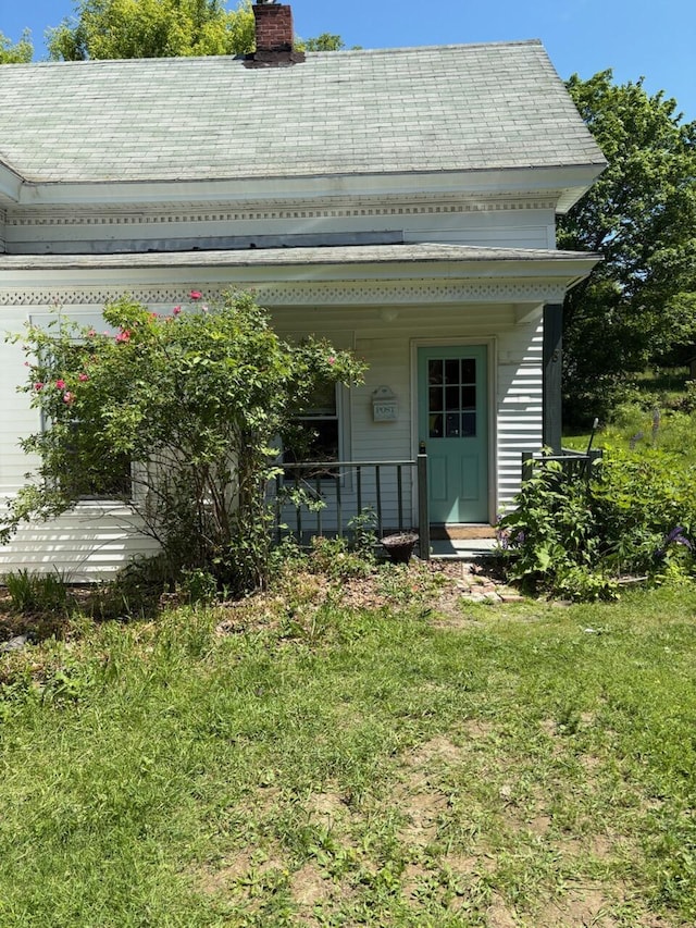 18 Clark St, Calais, ME 04619 - rear view of house featuring a chimney, a porch, and a yard
