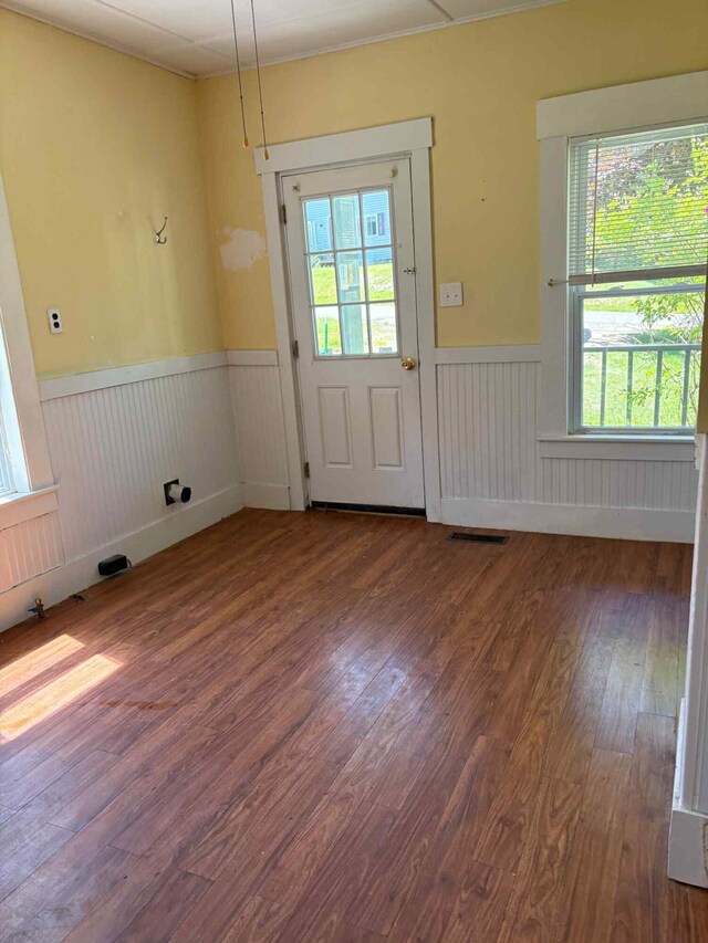 18 Clark St, Calais, ME 04619 - doorway to outside with wainscoting, wood finished floors, and healthy amount of natural light