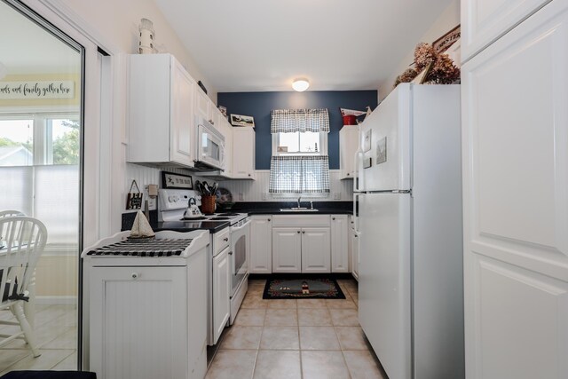 454 Post Rd Unit 464, Wells, ME 04090 - kitchen featuring white appliances, dark countertops, light tile patterned floors, and white cabinets
