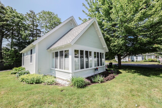 454 Post Rd Unit 464, Wells, ME 04090 - view of property exterior featuring a sunroom, a yard, and a shingled roof