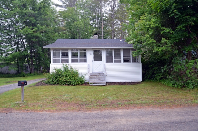 10 Stevens St, Norway, ME 04268 - view of front of home featuring a shingled roof, a front lawn, a sunroom, entry steps, and a chimney