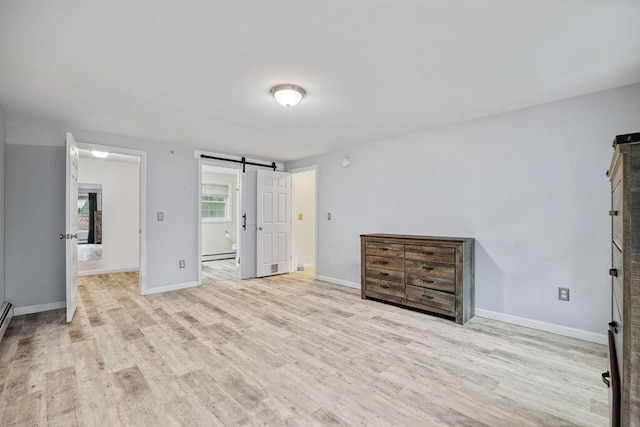 19 Fox Run Rd, Gray, ME 04039 - unfurnished bedroom featuring a barn door, wood finished floors, baseboard heating, and ensuite bathroom