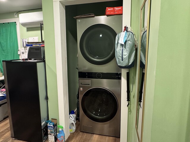 40 Elm St, Waterville, ME 04901 - laundry room with estacked washer and dryer, wood finished floors, and a wall mounted air conditioner