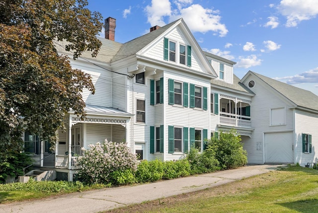 201 Main St, Norway, ME 04268 - view of front of property featuring covered porch, a garage, driveway, a chimney, and a balcony