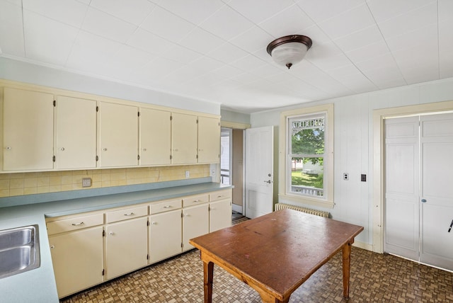 201 Main St, Norway, ME 04268 - kitchen with cream cabinetry, radiator, light flooring, and crown molding