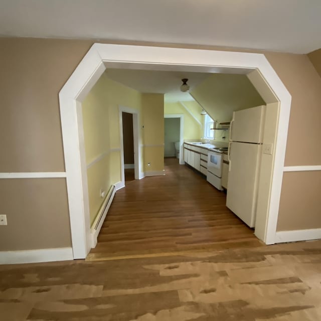 323 Pine St, Dover-Foxcroft, ME 04426 - hall featuring a baseboard heating unit, wood finished floors, and vaulted ceiling