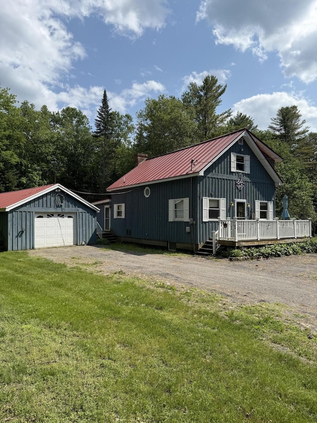 333 Mohawk Rd, Enfield, ME 04493 - view of side of property with board and batten siding, a garage, an outdoor structure, a lawn, and a metal roof