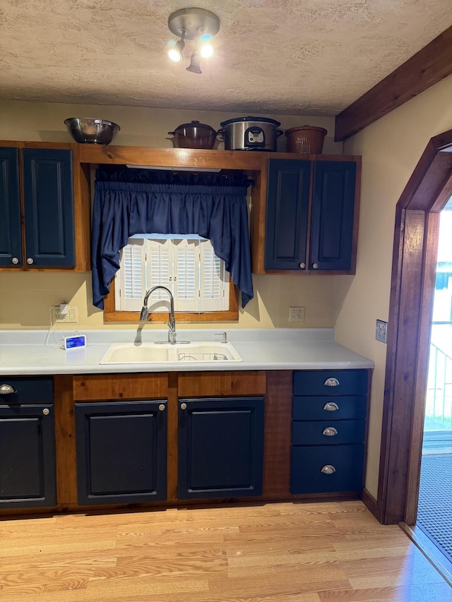 333 Mohawk Rd, Enfield, ME 04493 - kitchen featuring blue cabinets, light wood-style floors, light countertops, and a textured ceiling