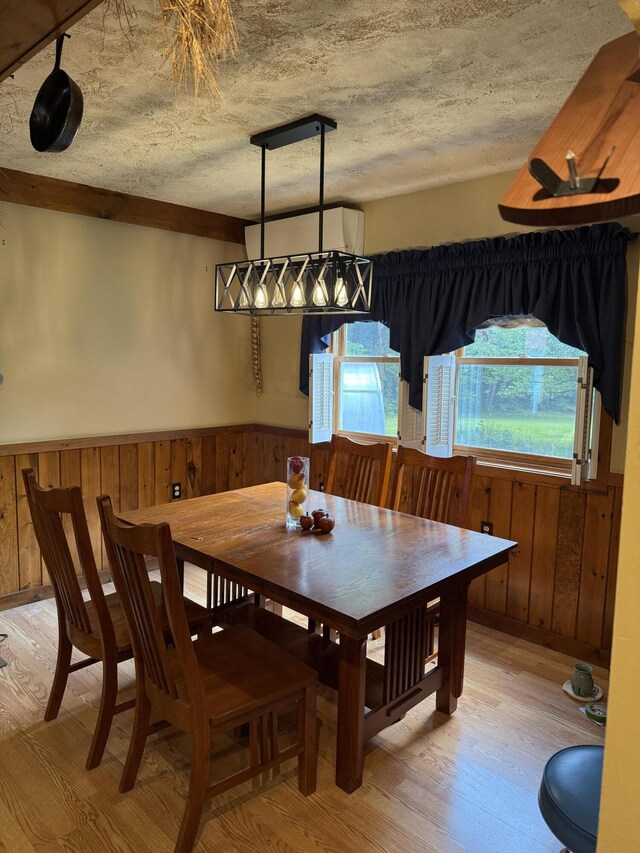 333 Mohawk Rd, Enfield, ME 04493 - dining room featuring healthy amount of natural light, light wood-style flooring, wooden walls, and a wainscoted wall