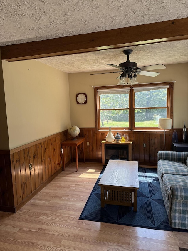 333 Mohawk Rd, Enfield, ME 04493 - living area with wainscoting, beamed ceiling, plenty of natural light, light wood-type flooring, and ceiling fan