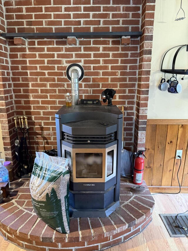 333 Mohawk Rd, Enfield, ME 04493 - detailed view of a wood stove, wood finished floors, and wainscoting