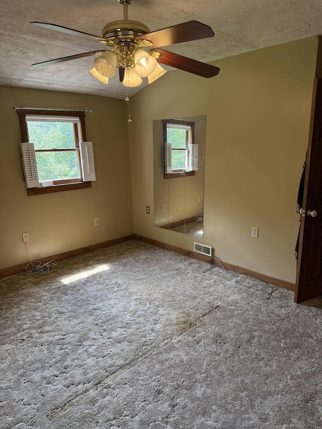 333 Mohawk Rd, Enfield, ME 04493 - carpeted empty room with healthy amount of natural light, a textured ceiling, and a ceiling fan