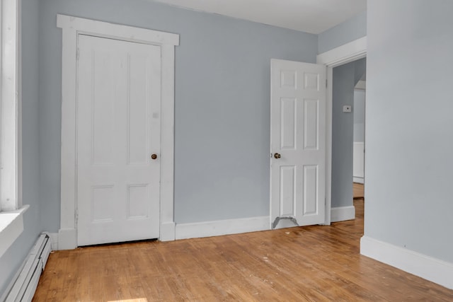 120 Holland St, Lewiston, ME 04240 - unfurnished bedroom with a baseboard heating unit and light wood-type flooring