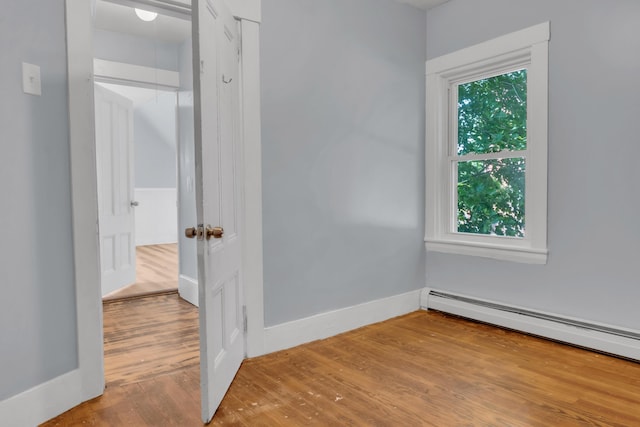 120 Holland St, Lewiston, ME 04240 - empty room with baseboard heating and wood finished floors