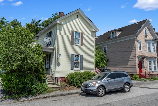 120 Holland St, Lewiston, ME 04240 - view of front facade with a chimney, entry steps, and cooling unit