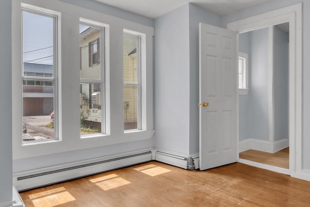 120 Holland St, Lewiston, ME 04240 - empty room featuring light wood-style floors, plenty of natural light, and a baseboard heating unit