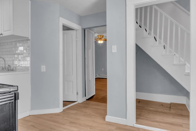 120 Holland St, Lewiston, ME 04240 - stairway with a baseboard heating unit, wood finished floors, and a ceiling fan