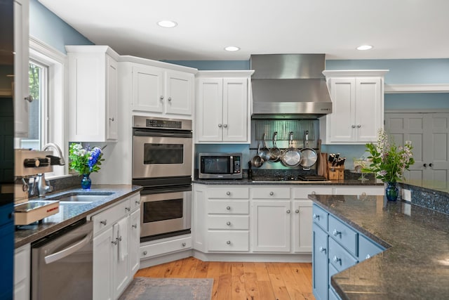 6 Ocean View Dr, Biddeford, ME 04005 - kitchen featuring wall chimney range hood, appliances with stainless steel finishes, white cabinetry, light wood finished floors, and recessed lighting