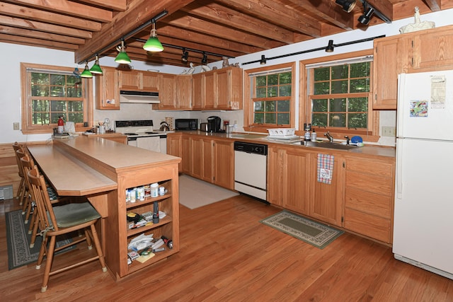 105 Highland Pines Rd, Bridgton, ME 04009 - kitchen featuring white appliances, under cabinet range hood, light wood-style flooring, beamed ceiling, and decorative light fixtures