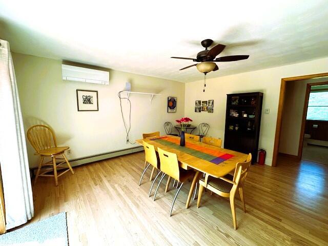 429 Moosehead Trail Highway, Waldo, ME 04915 - dining room with a wall mounted air conditioner, baseboard heating, light wood-type flooring, and a ceiling fan