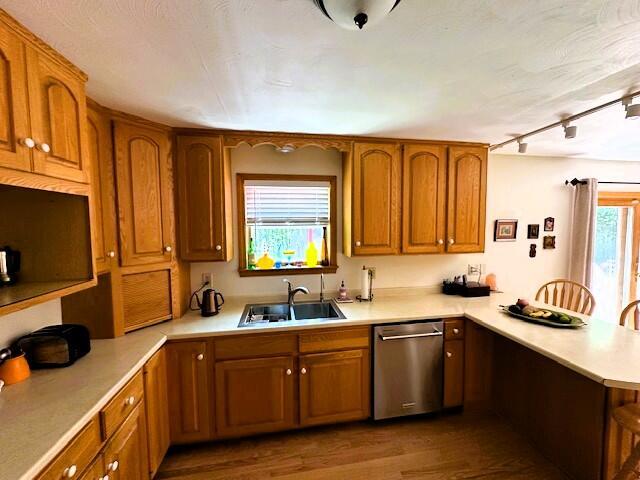 429 Moosehead Trail Highway, Waldo, ME 04915 - kitchen featuring stainless steel dishwasher, a peninsula, brown cabinets, light countertops, and wood finished floors