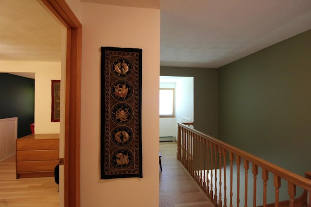 429 Moosehead Trail Highway, Waldo, ME 04915 - hallway with wood finished floors, baseboard heating, and an upstairs landing