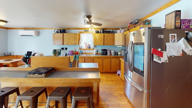 37 Mill St, Enfield, ME 04493 - kitchen with stainless steel refrigerator with ice dispenser, a wall unit AC, light wood-style floors, a ceiling fan, and a breakfast bar area
