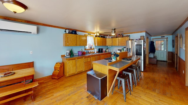 37 Mill St, Enfield, ME 04493 - kitchen featuring an AC wall unit, stainless steel refrigerator with ice dispenser, light wood finished floors, crown molding, and a ceiling fan