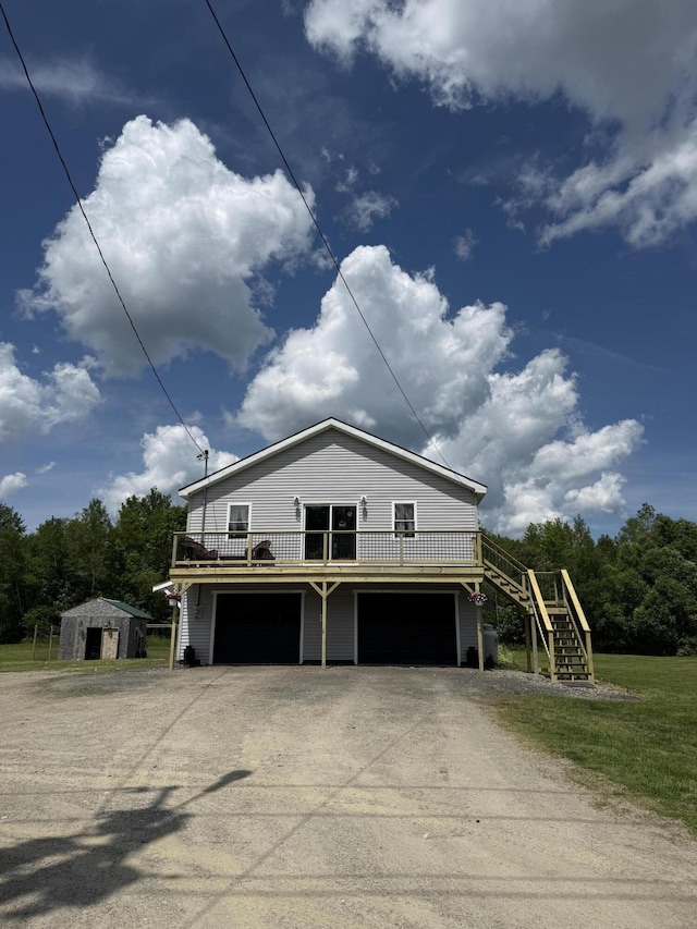 37 Mill St, Enfield, ME 04493 - view of front of house featuring an attached garage, stairway, driveway, a deck, and a storage unit