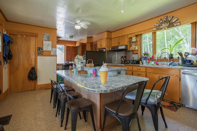 210 Middle St, Farmington, ME 04938 - kitchen featuring dishwasher, ceiling fan, light countertops, under cabinet range hood, and a kitchen bar