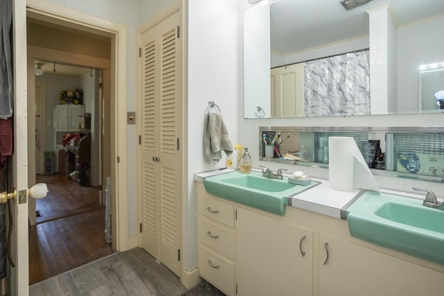 210 Middle St, Farmington, ME 04938 - bathroom featuring a closet, double vanity, ornamental molding, and wood finished floors