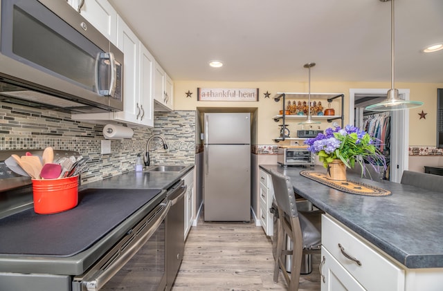 3 Pondview Dr, Lewiston, ME 04240 - kitchen with stainless steel appliances, dark countertops, white cabinetry, light wood-type flooring, and decorative backsplash