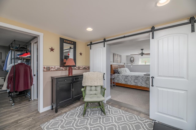 3 Pondview Dr, Lewiston, ME 04240 - bedroom featuring a barn door, wood finished floors, and recessed lighting