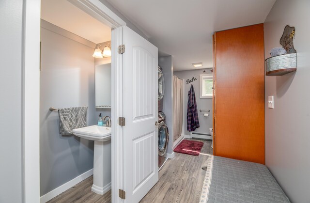 3 Pondview Dr, Lewiston, ME 04240 - full bathroom with stacked washer / drying machine, a baseboard heating unit, wood finished floors, and a shower with shower curtain