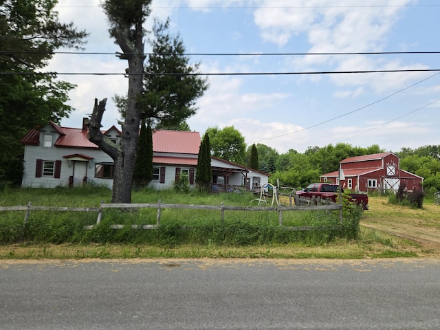 192 Old Bangor Rd, Newport, ME 04953 - view of front of house with a barn, a chimney, an outbuilding, dirt driveway, and a metal roof