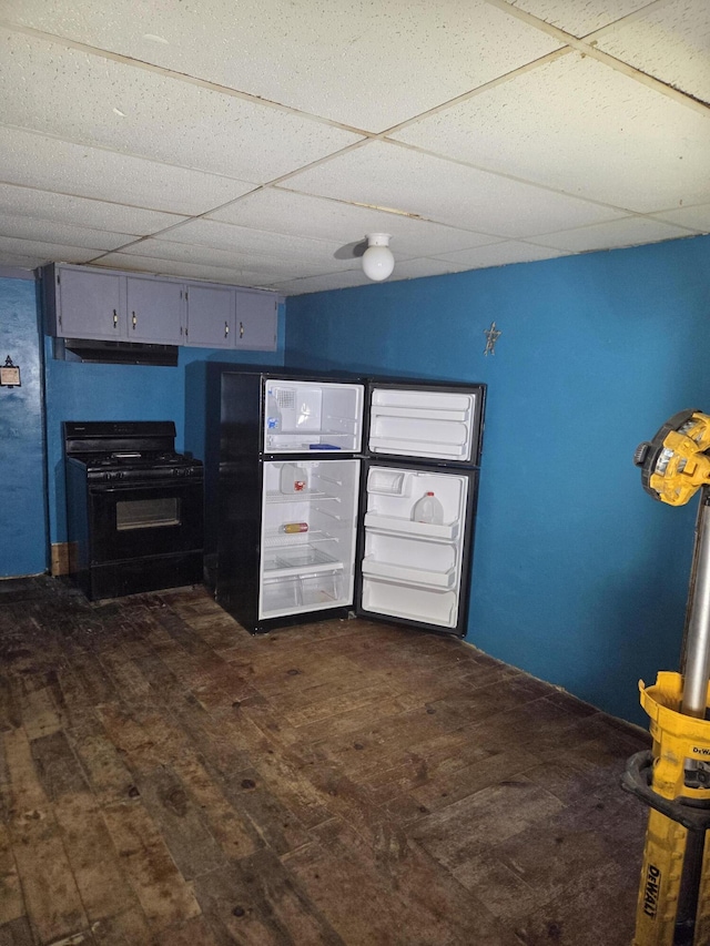 192 Old Bangor Rd, Newport, ME 04953 - kitchen featuring gas stove, a drop ceiling, dark wood-type flooring, under cabinet range hood, and freestanding refrigerator