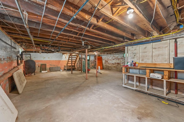 25 Foch St, Lewiston, ME 04240 - unfinished basement with oil tank, stairs, radiator heating unit, and gas water heater