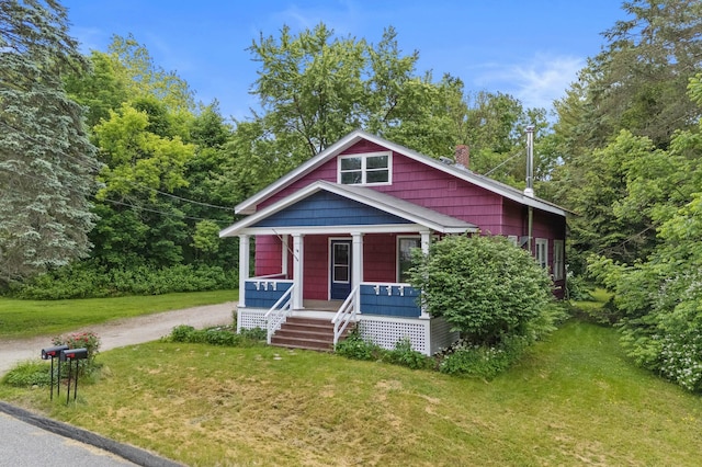 25 Foch St, Lewiston, ME 04240 - view of front of property with covered porch, a chimney, a front yard, and dirt driveway