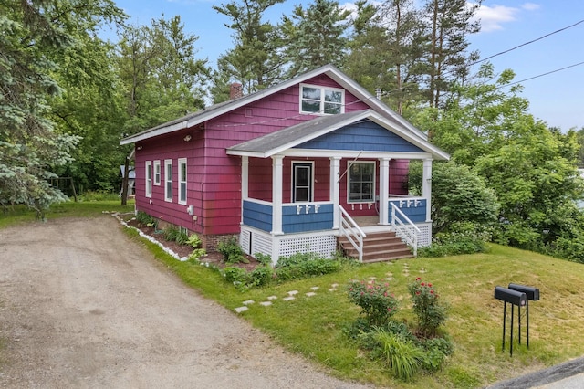 25 Foch St, Lewiston, ME 04240 - view of front facade featuring a porch, a chimney, dirt driveway, and a front yard