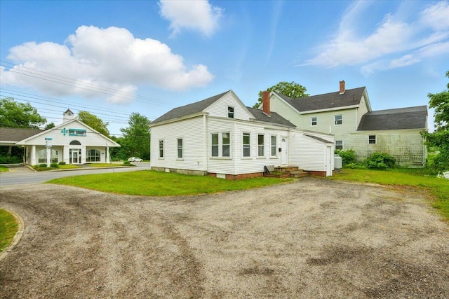 219 Lisbon St, Lisbon, ME 04250 - rear view of property featuring a chimney and a lawn