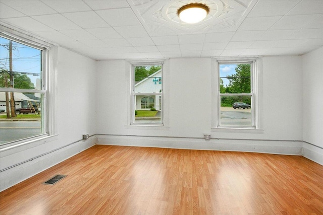 219 Lisbon St, Lisbon, ME 04250 - empty room featuring light wood-style floors, plenty of natural light, and a paneled ceiling