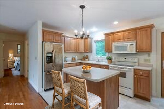 404 Lower Round Pond Rd, Bristol, ME 04539 - kitchen featuring white appliances, light countertops, a chandelier, a center island, and a kitchen bar