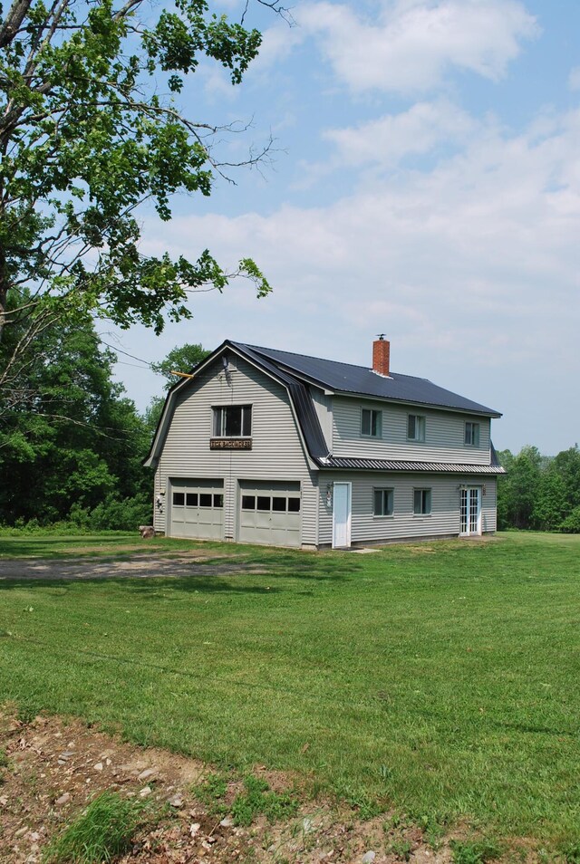 180 Chadbourne Rd, Harmony, ME 04942 - rear view of house with a gambrel roof, a metal roof, a chimney, driveway, and a lawn