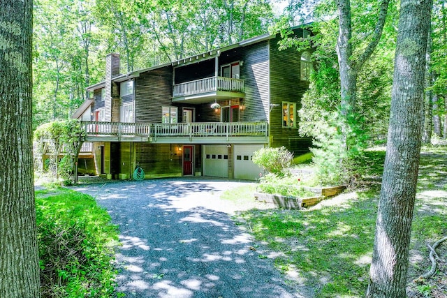 619 Shore Rd, Northport, ME 04849 - view of front of home featuring a balcony, a chimney, a garage, and driveway